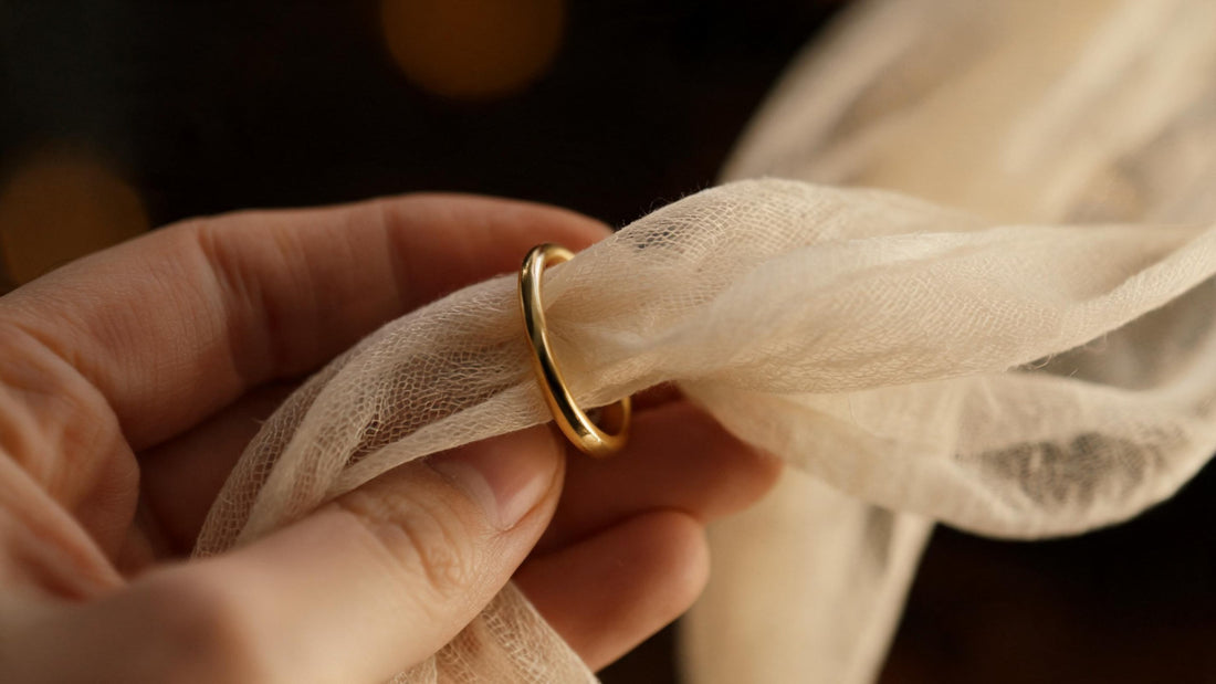 Hand drawing a fine cream pashmina through a small gold ring