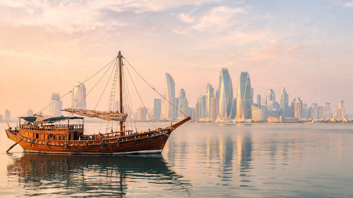 Traditional wooden dhow on calm water before the Doha skyline at golden hour