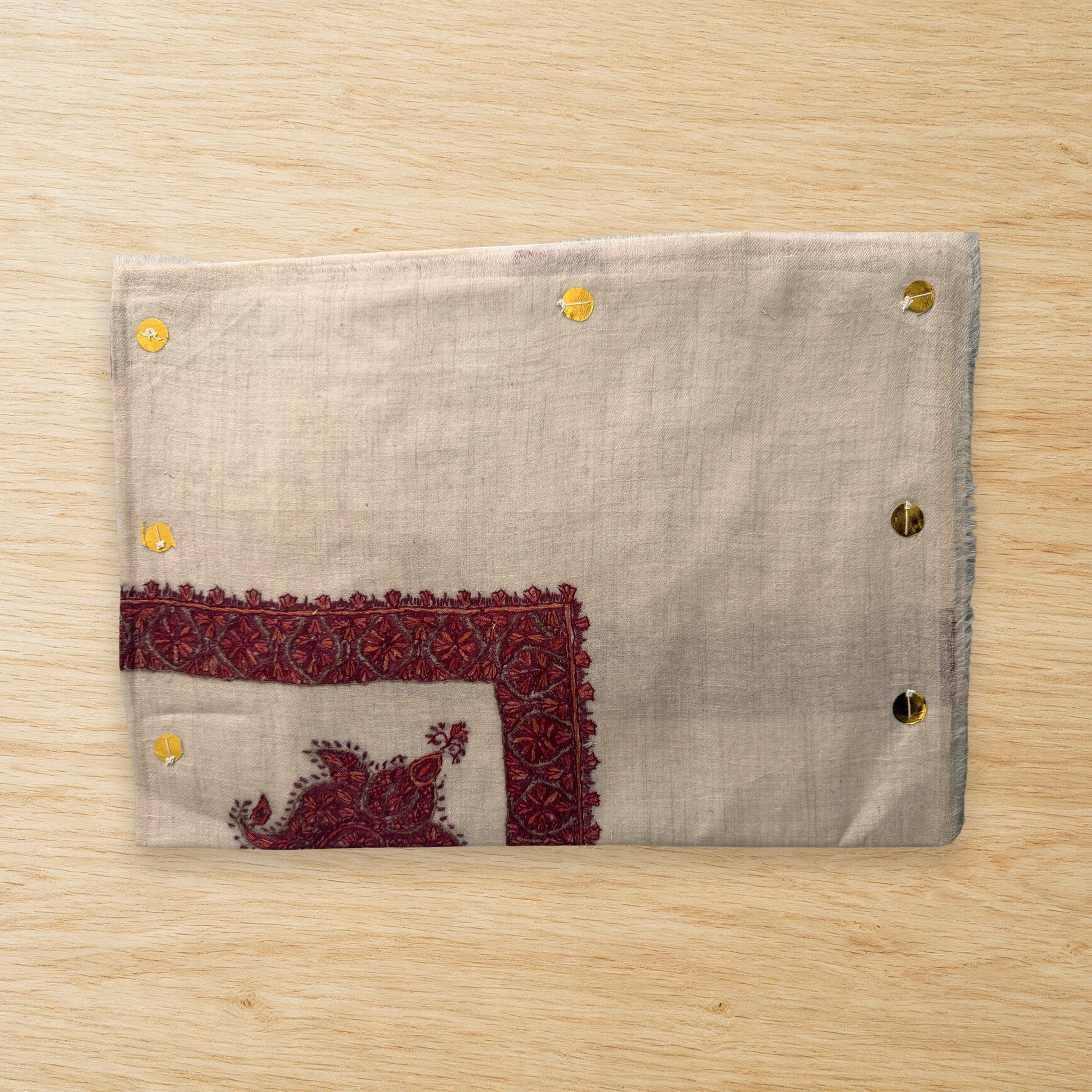 Yaqoot Kashmiri pashmina ghutra laid flat on a wooden table, true to life colour