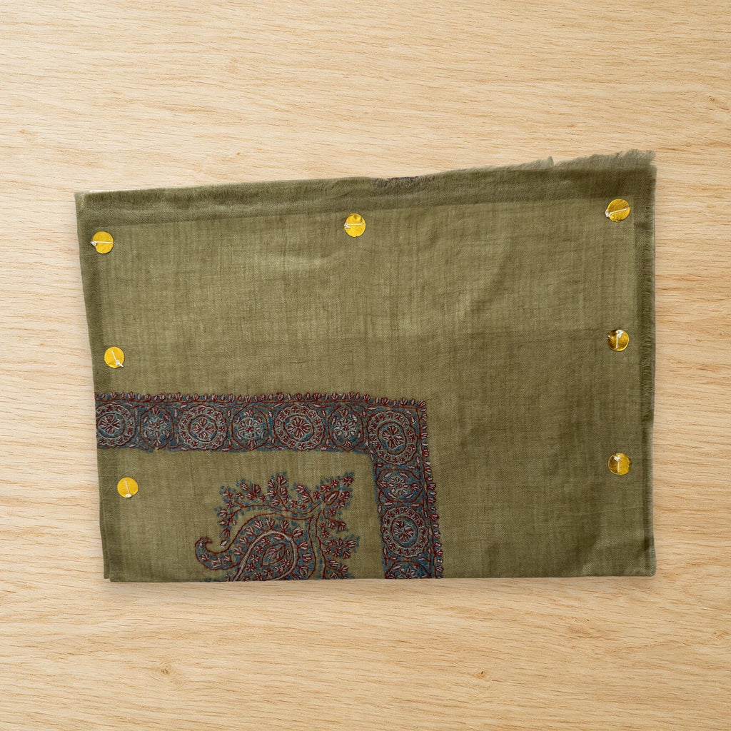 Jannah olive green Kashmiri pashmina ghutra laid flat on a wooden table, true to life colour