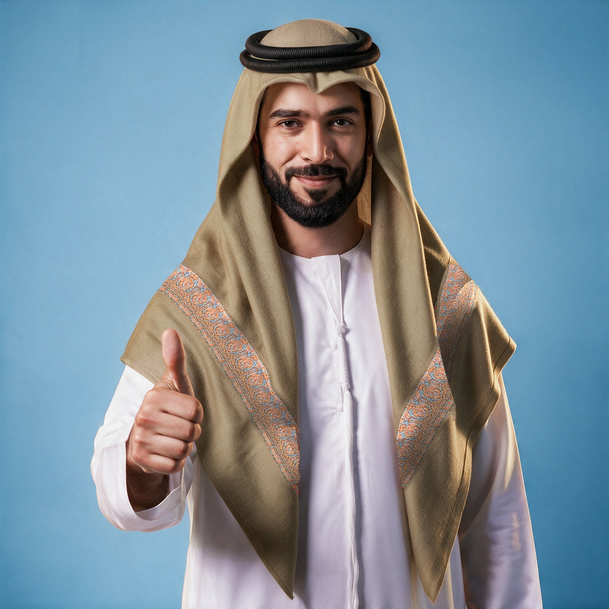 Man wearing the Bunn Kashmiri pashmina ghutra in taupe brown with a black agal and white thobe, coral and turquoise sozni border on each front end