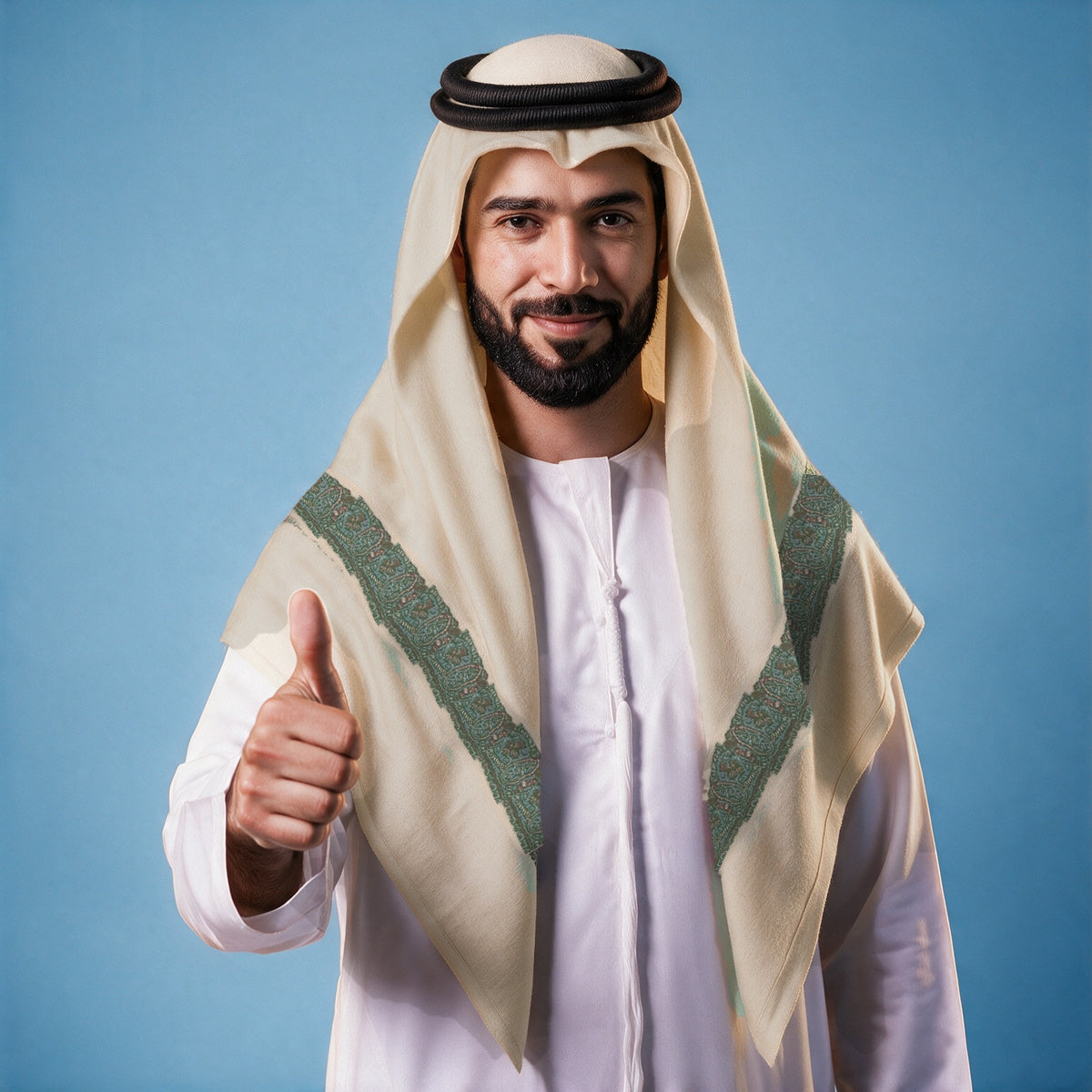 Man wearing the Zumurrud Kashmiri pashmina ghutra with a black agal and white thobe, teal and rust sozni border on each front end