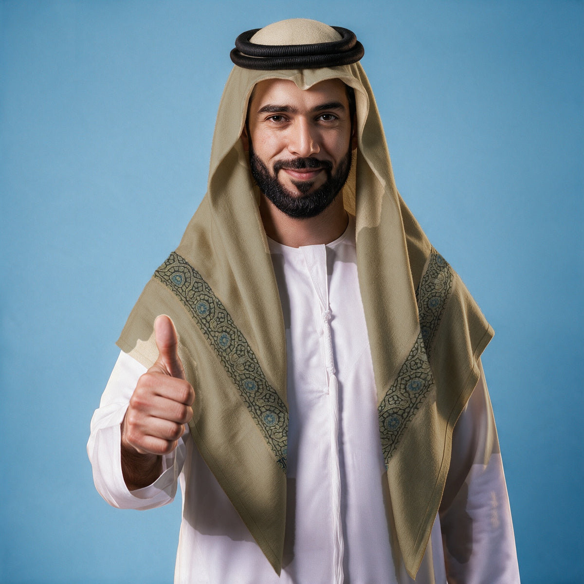 Man wearing the Sarw Kashmiri pashmina ghutra in khaki olive with a black agal and white thobe, slate navy and sky blue sozni border on each front end