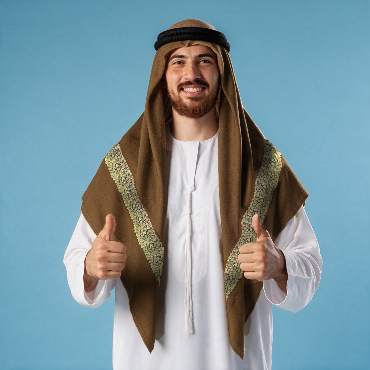 Man wearing the Thalj Kashmiri pashmina ghutra in chocolate brown with a black agal and white thobe, cream, teal and peach sozni border on each front end