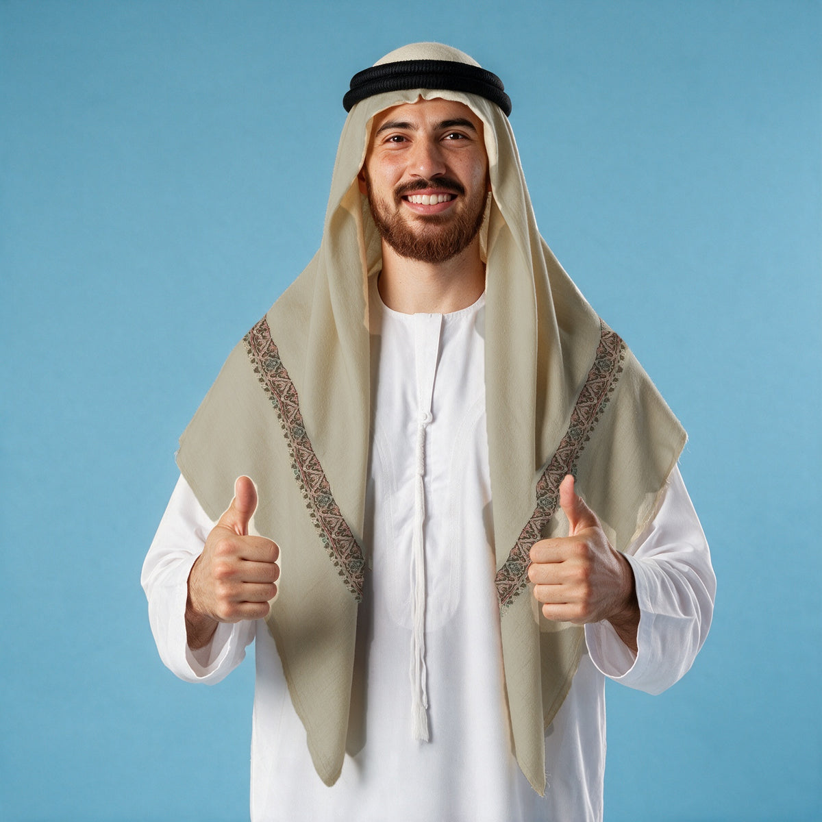 Man wearing the Rabee Kashmiri pashmina ghutra with a black agal and white thobe, pink and grey-green sozni border on each front end