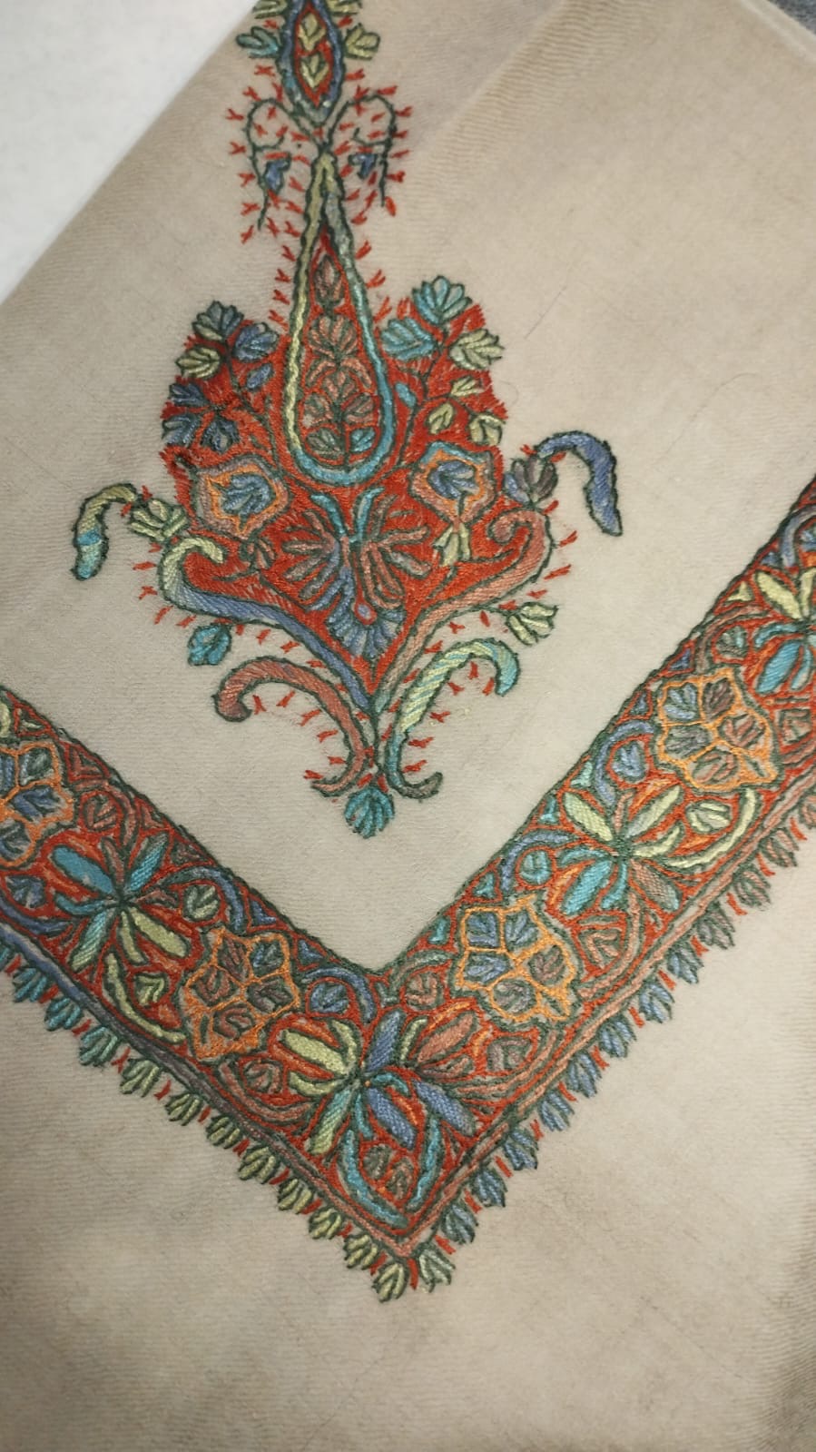 Qaws Kashmiri pashmina ghutra corner seen on the diagonal, the border meeting in a point below the motif
