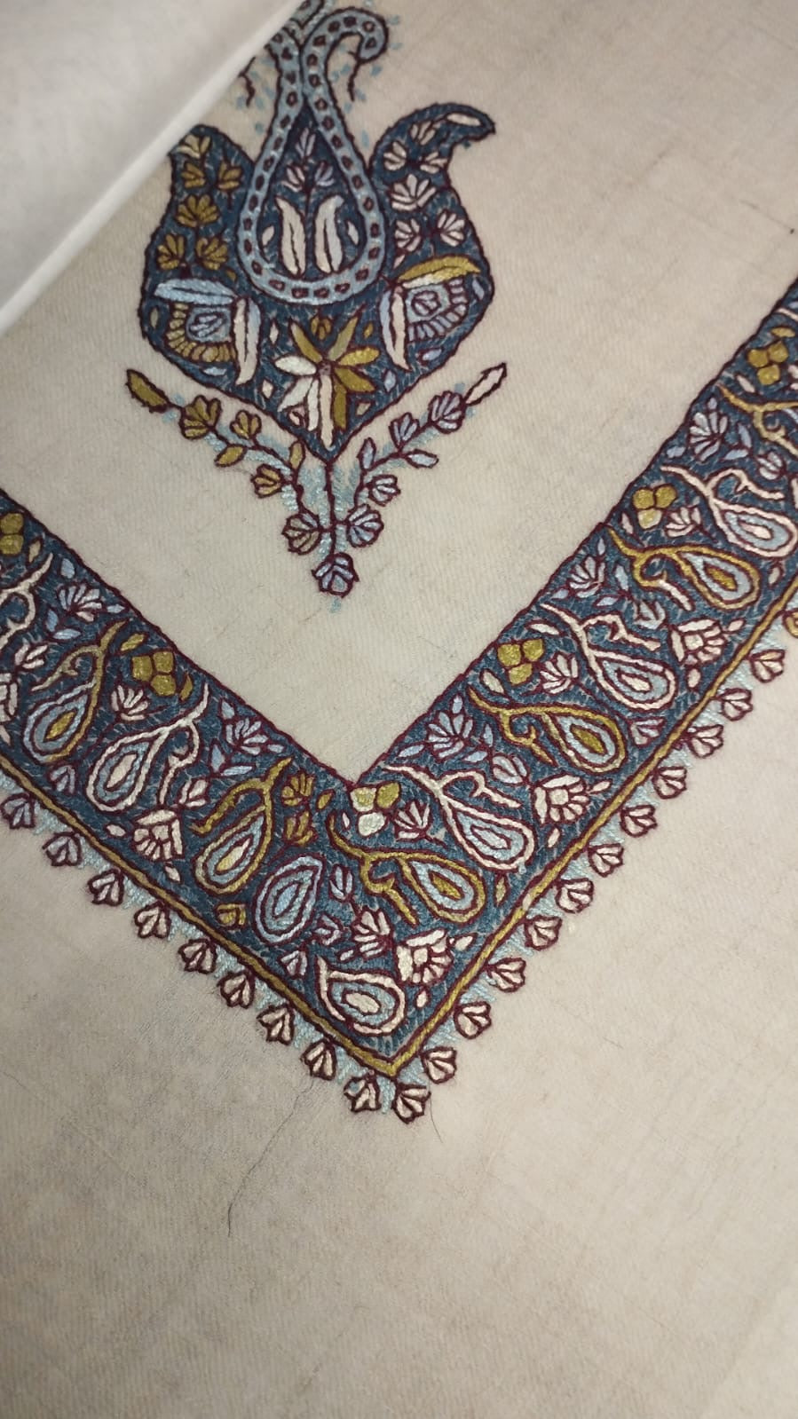 Nujoom Kashmiri pashmina ghutra corner seen on the diagonal, the border meeting in a point below the motif