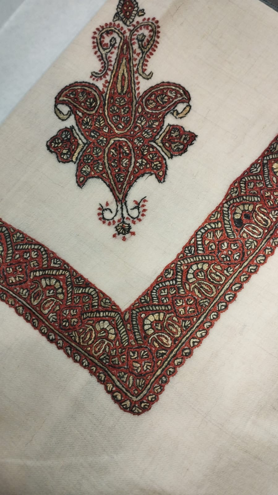 Unnab Kashmiri pashmina ghutra corner seen on the diagonal, the border meeting in a point below the motif