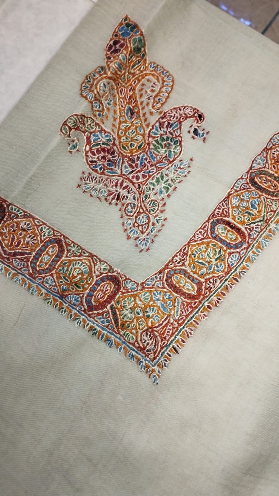 Kanz Kashmiri pashmina ghutra corner seen on the diagonal, the border meeting in a point below the motif