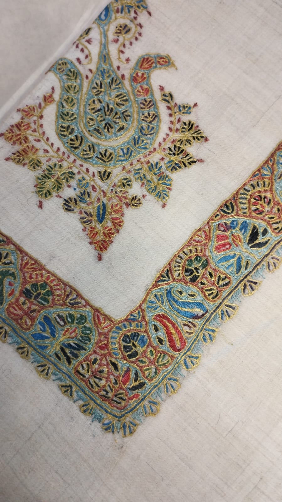 Fustuq Kashmiri pashmina ghutra corner seen on the diagonal, the border meeting in a point below the motif