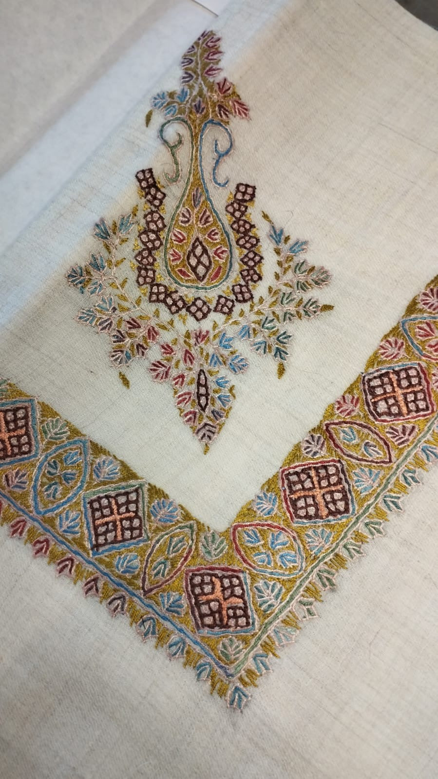 Zarabi Kashmiri pashmina ghutra corner seen on the diagonal, the border meeting in a point below the motif