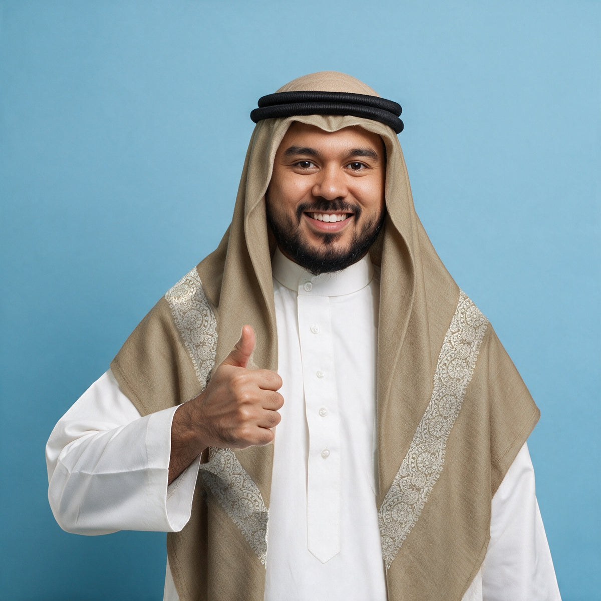 Man wearing the Durra Qalam Kaari Super Turma Kashmiri semi pashmina in camel with a black agal and white thobe, ivory white pen-work border on each front end