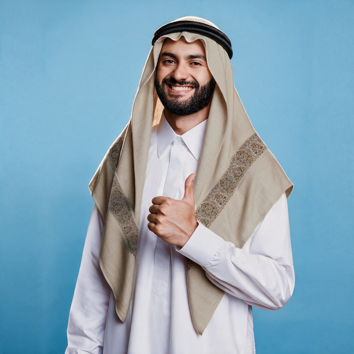 Man wearing the Golab Qalam Kaari Super Turma Kashmiri semi pashmina in light warm greige with a black agal and white thobe, pastel pink, gold and light blue multicolour pen-work border on each front end