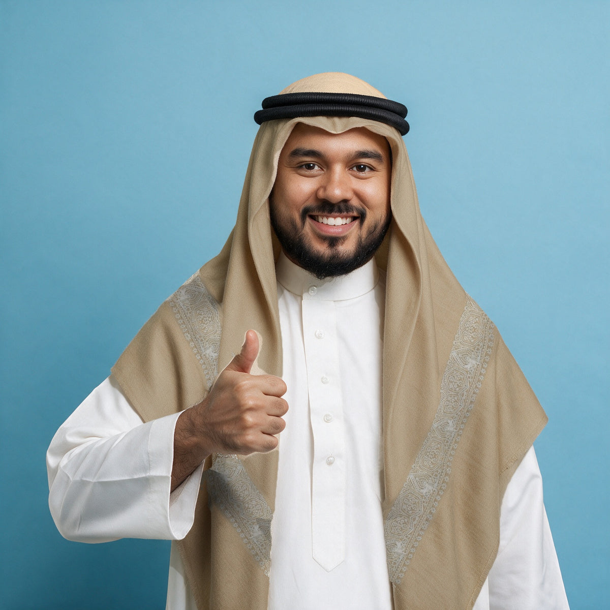 Man wearing the Yasmin Qalam Kaari Super Turma Kashmiri semi pashmina in warm sand beige with a black agal and white thobe, ivory white pen-work border on each front end