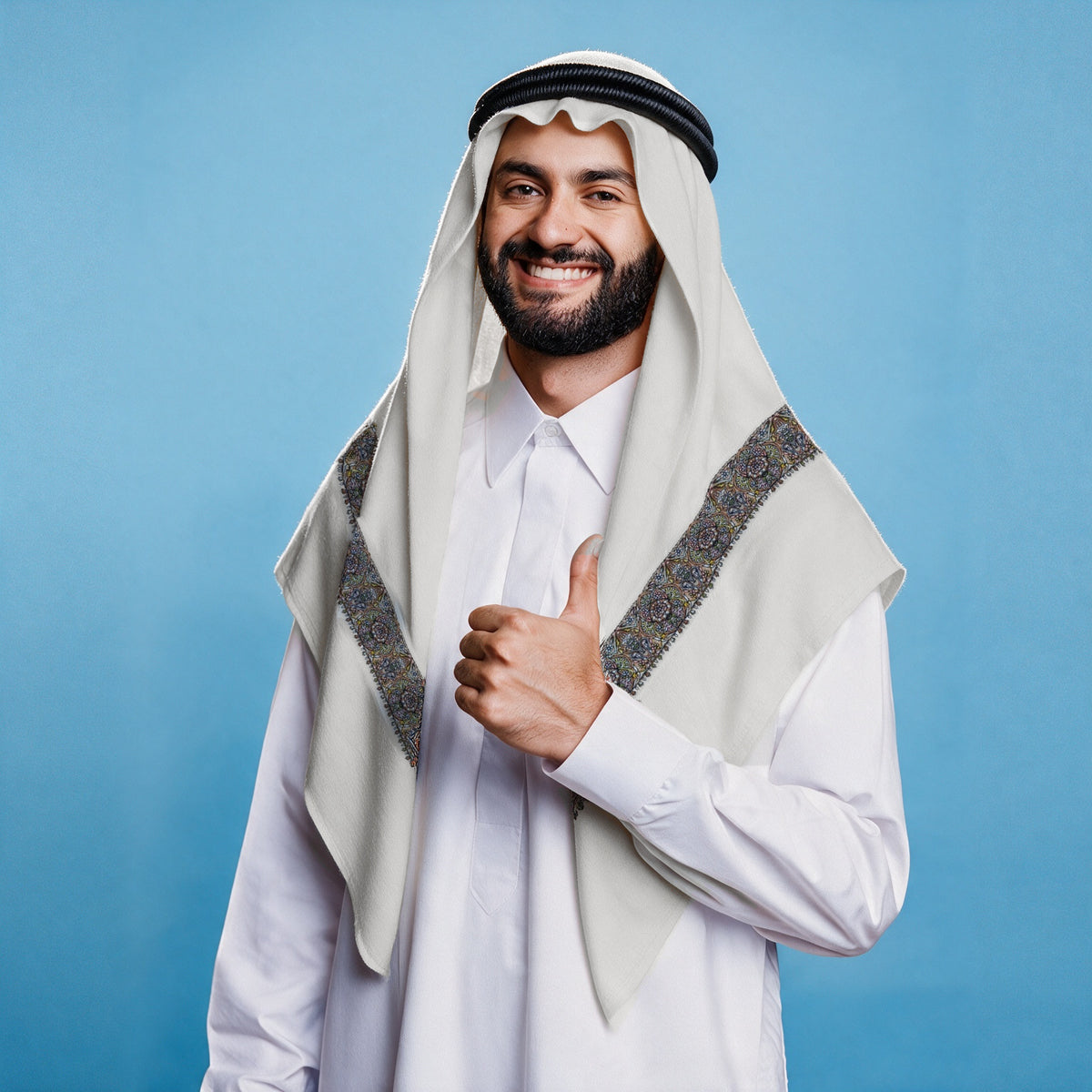 Man wearing the Layl Qalam Kaari Super Turma Kashmiri semi pashmina in soft natural white with a black agal and white thobe, dense indigo, brown, pastel pink and yellow multicolour pen-work border on each front end