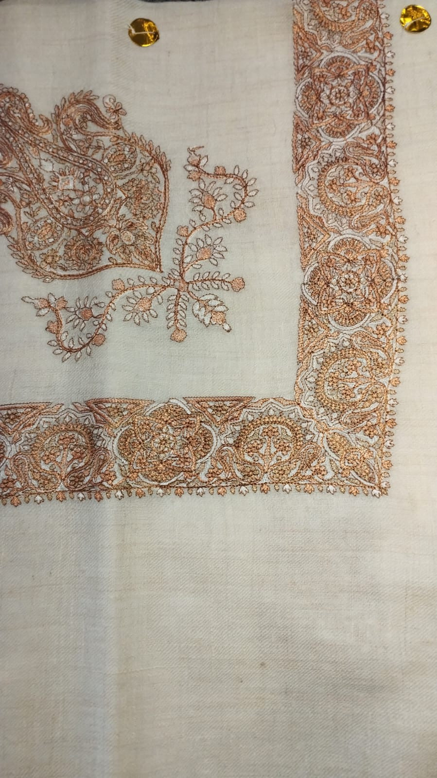 Surur Qalam Kaari Pashmina laid flat, copper and ivory paisley corner motif and rosette border on a natural oatmeal ground