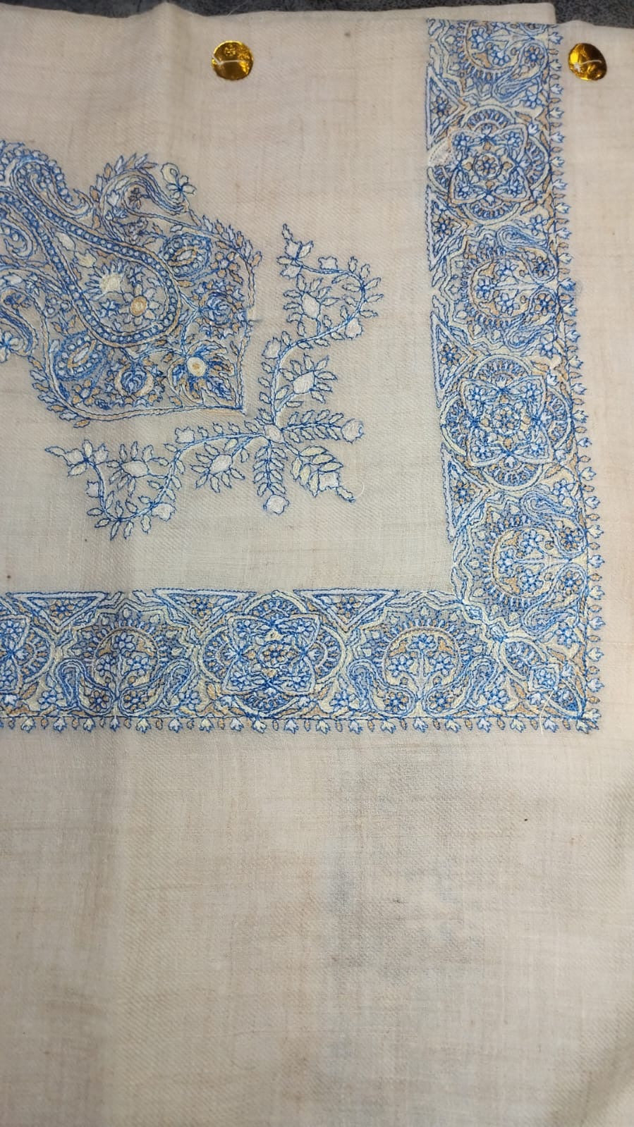 Darya Qalam Kaari Pashmina laid flat, sky blue and ivory paisley corner motif and rosette border on a natural oatmeal ground