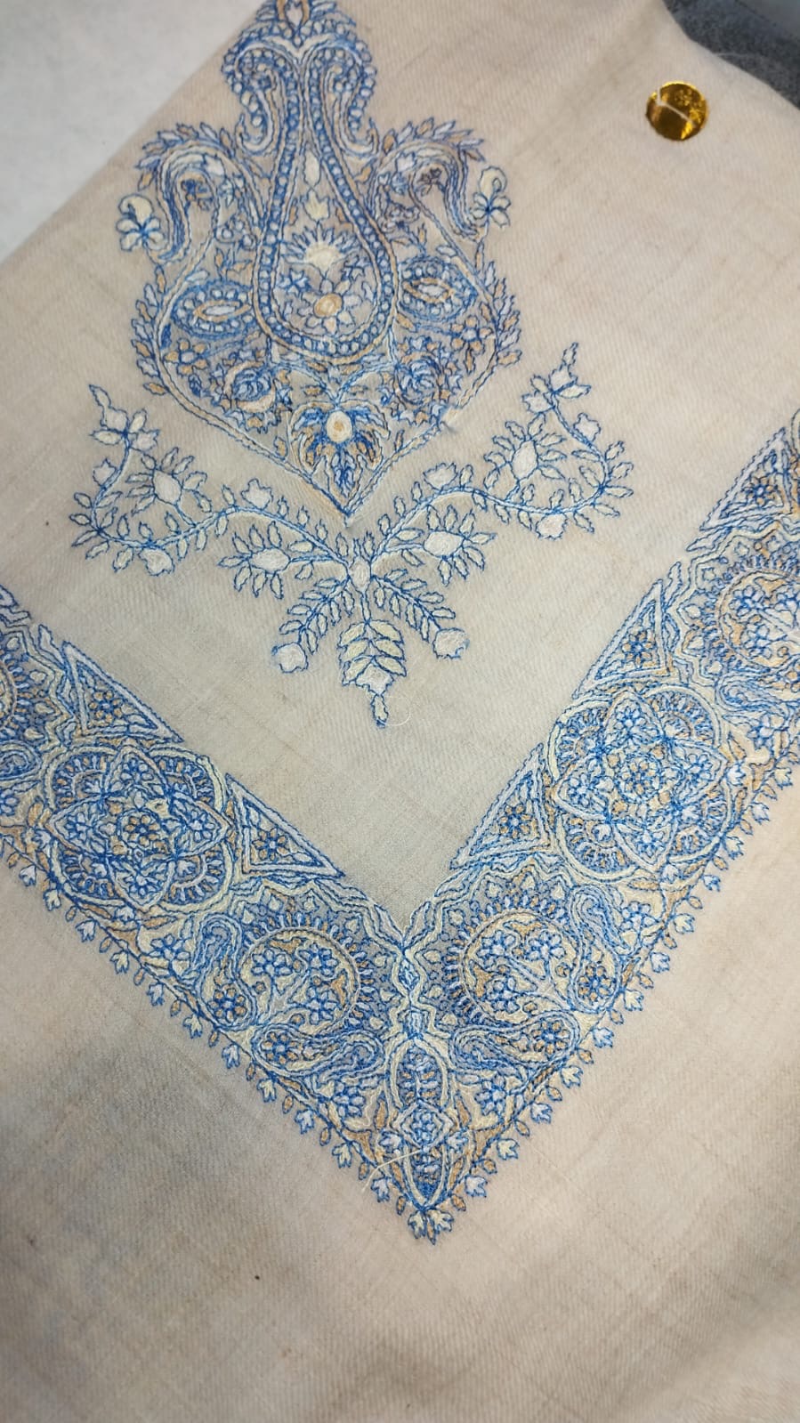 Darya Qalam Kaari Pashmina folded to a point at the corner, showing the sky blue and ivory paisley motif and rosette border