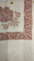 Qasida Qalam Kaari Pashmina laid flat, madder red, cream and slate blue paisley corner motif and rosette border on a natural oatmeal ground
