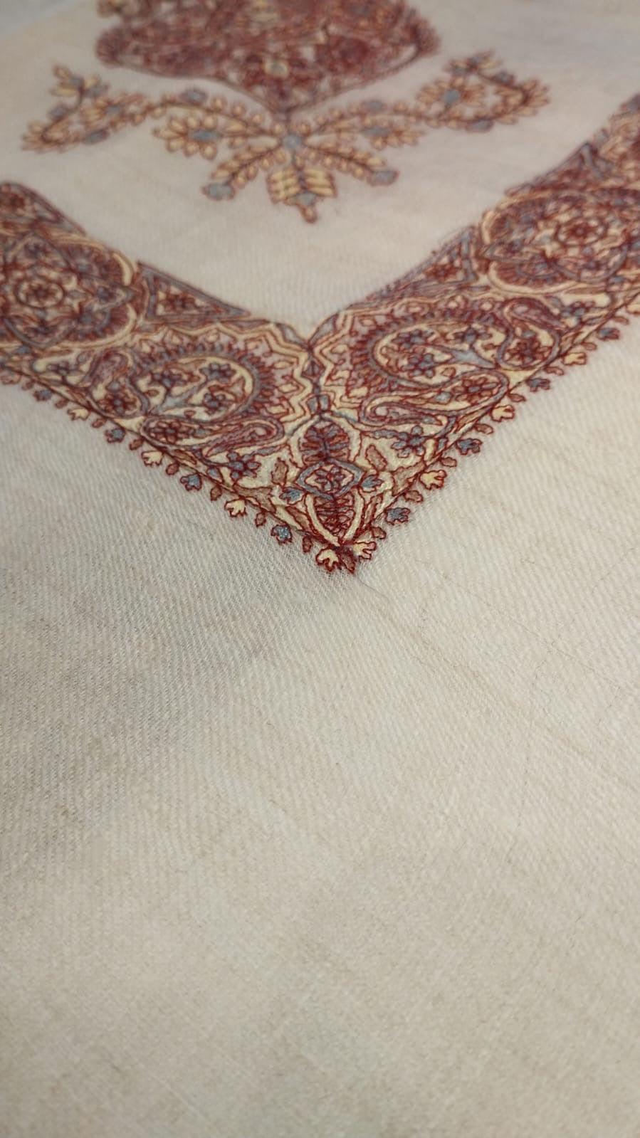 Close view of the Qasida Qalam Kaari Pashmina corner, madder red, cream and slate blue hand-drawn sozni