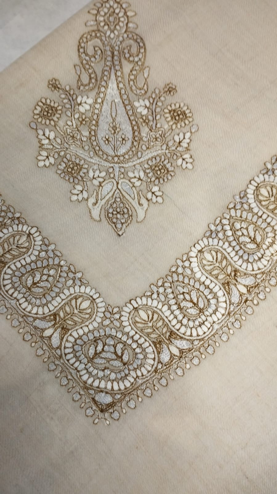 Lubban Qalam Kaari Pashmina folded to a point at the corner, showing the ivory and khaki paisley motif and winding paisley border