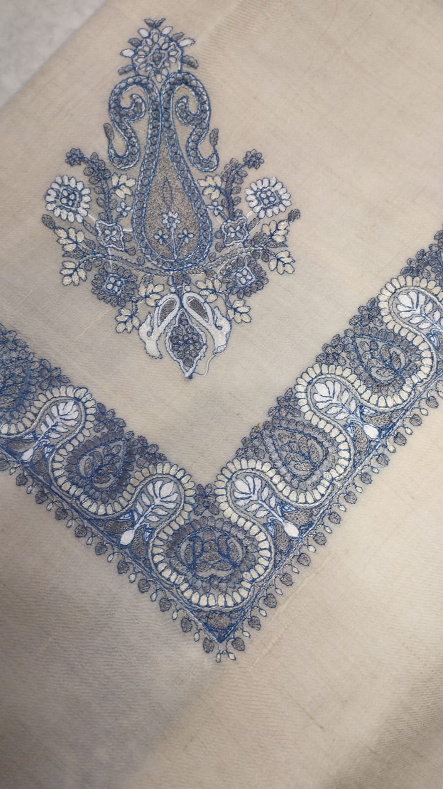 Mihbara Qalam Kaari Pashmina folded to a point at the corner, showing the faded indigo and ivory paisley motif and winding paisley border
