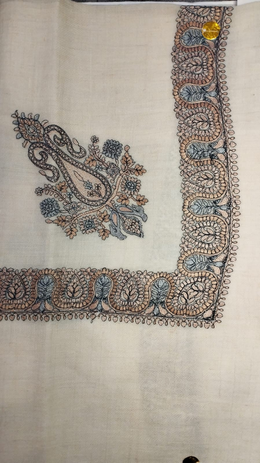 Yaraa Qalam Kaari Pashmina laid flat, apricot, charcoal and powder blue paisley corner motif and winding paisley border on a natural oatmeal ground