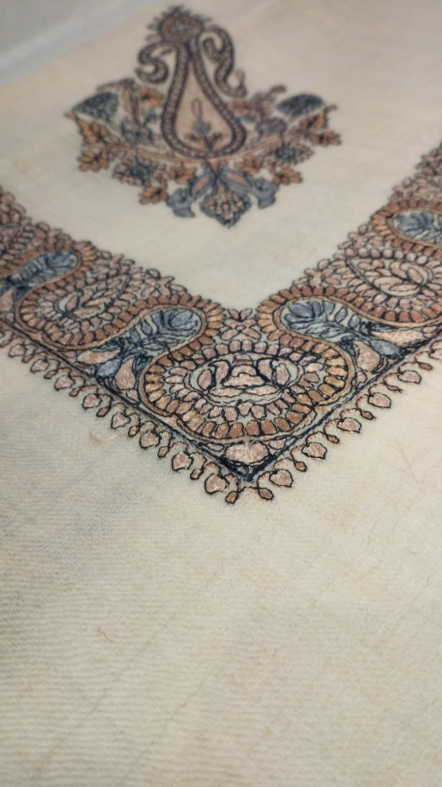 Close view of the Yaraa Qalam Kaari Pashmina corner, apricot, charcoal and powder blue hand-drawn sozni