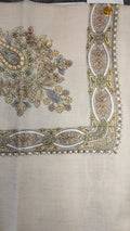 Zanbaq Qalam Kaari Pashmina laid flat, butter yellow, dusty rose and grey-blue floral bouquet corner motif and interlaced ribbon border on a natural oatmeal ground