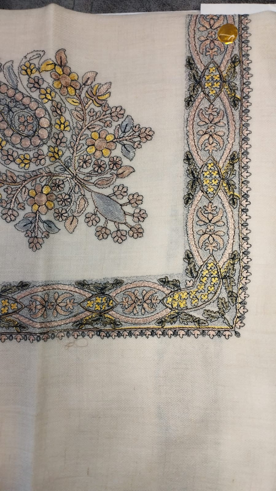 Hikaya Qalam Kaari Pashmina laid flat, blush pink, yellow and grey-blue floral bouquet corner motif and interlaced ribbon border on a natural oatmeal ground