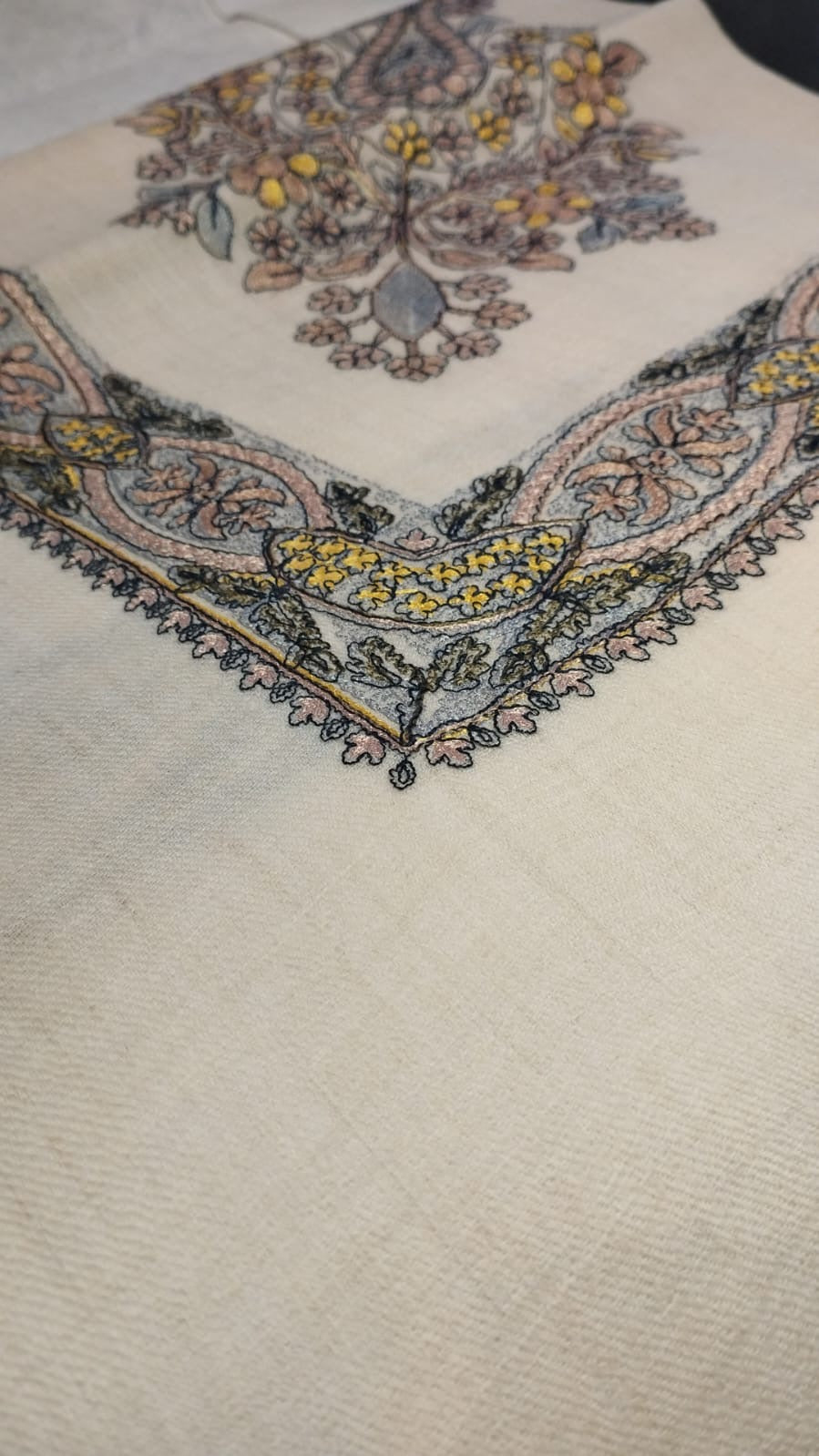 Close view of the Hikaya Qalam Kaari Pashmina corner, blush pink, yellow and grey-blue hand-drawn sozni