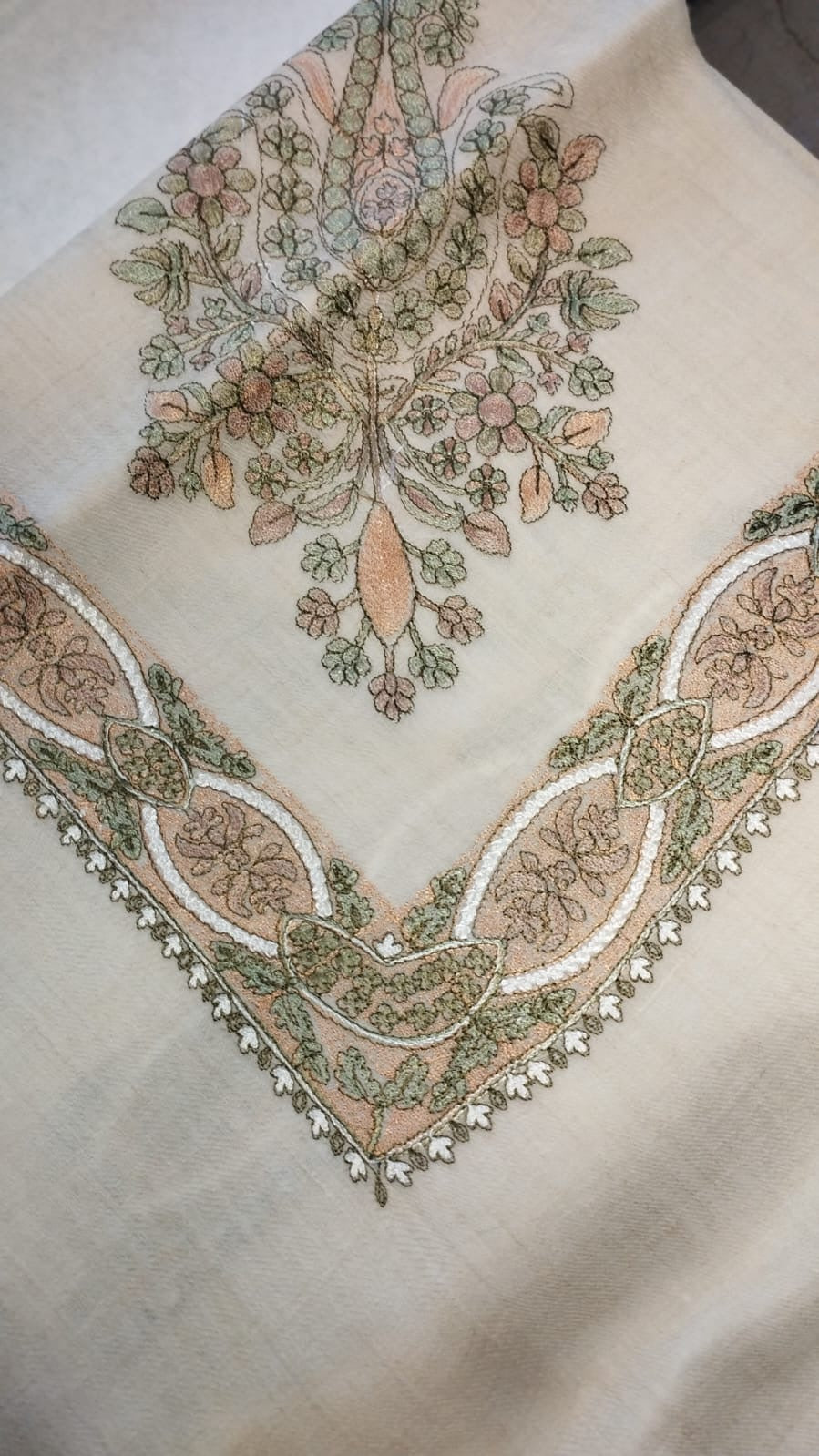 Nastaliq Qalam Kaari Pashmina folded to a point at the corner, showing the dusty pink, sage and ivory floral bouquet motif and interlaced ribbon border