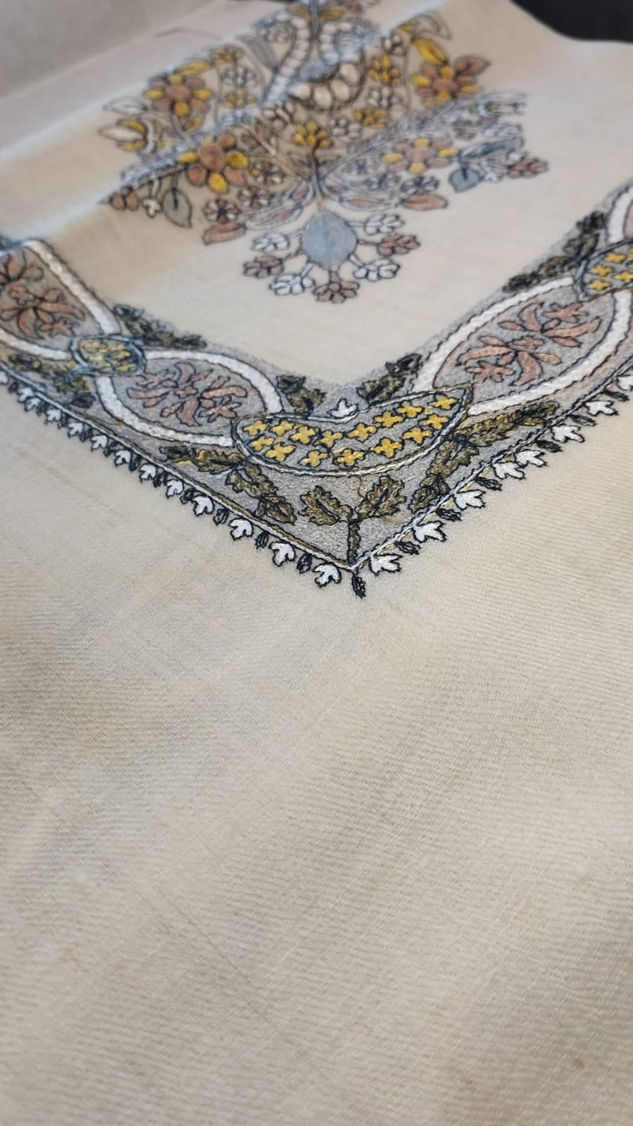 Close view of the Simurgh Qalam Kaari Pashmina corner, saffron yellow, grey-blue and rose hand-drawn sozni