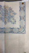 Marsa Qalam Kaari Pashmina laid flat, sky blue and apricot floral bouquet corner motif and interlaced ribbon border on a natural oatmeal ground