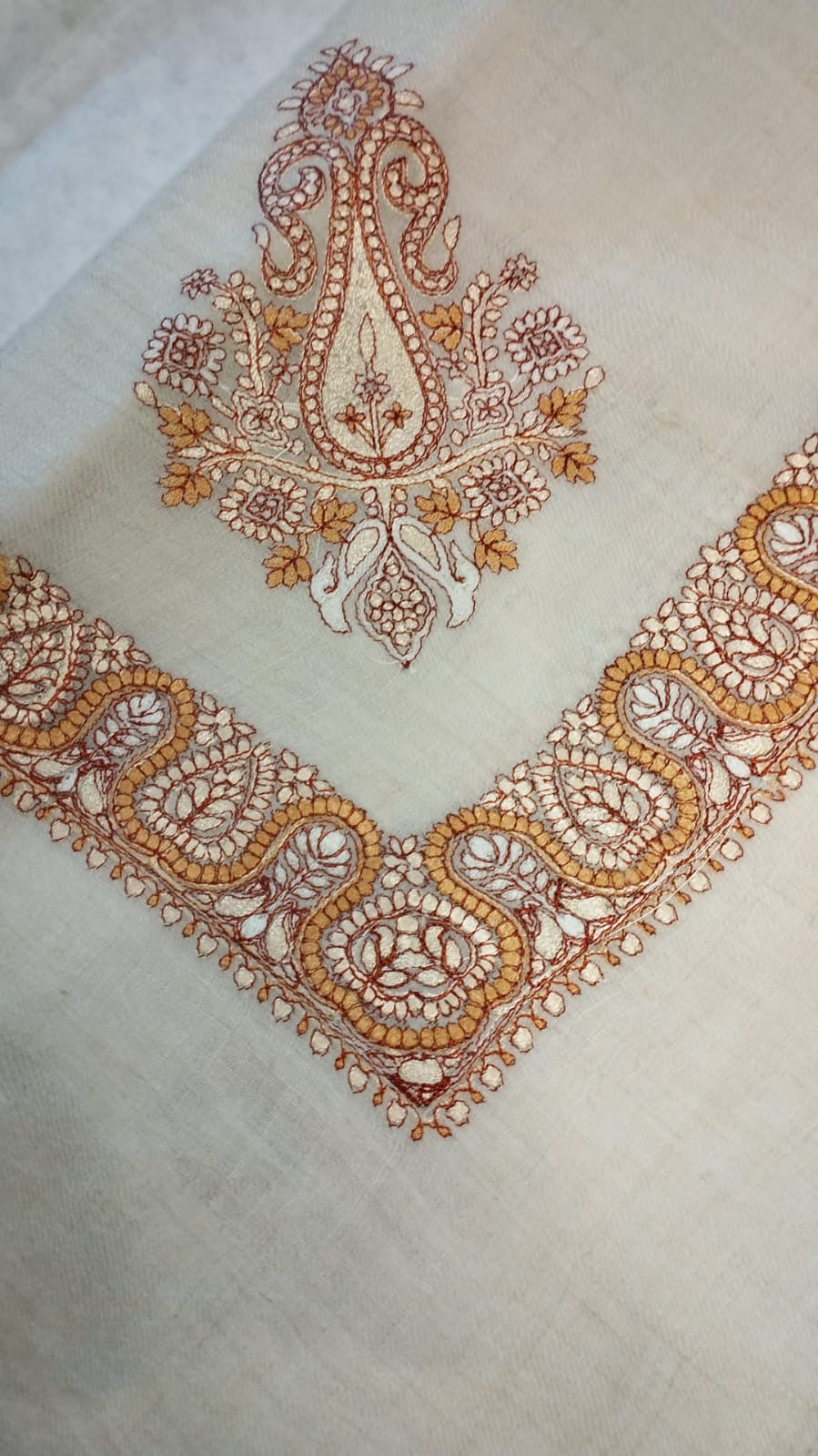Qandil Qalam Kaari Pashmina folded to a point at the corner, showing the marigold and rust paisley motif and winding paisley border